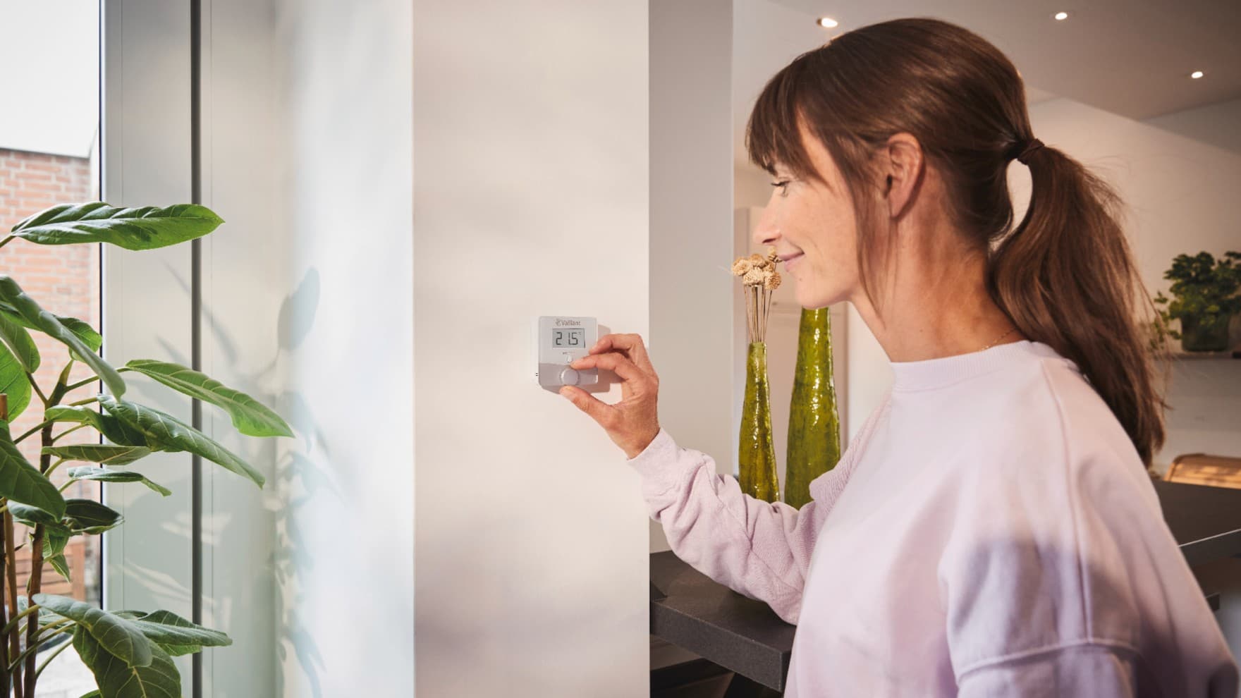 Žena koristi Vaillant sensoROOM termostat