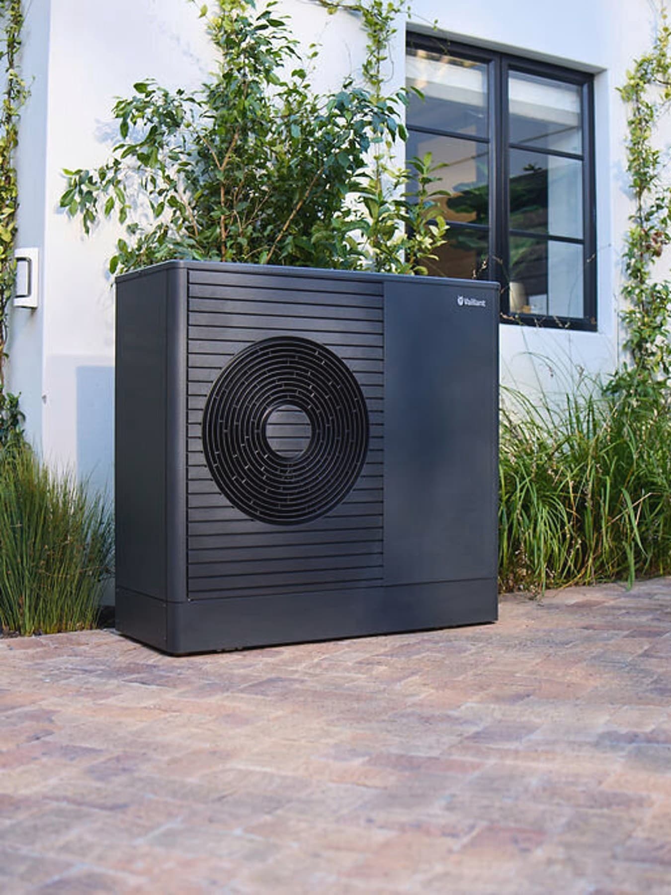 Tamna Vaillant aroTHERM plus toplotna pumpa u prednjem vrtu kuće