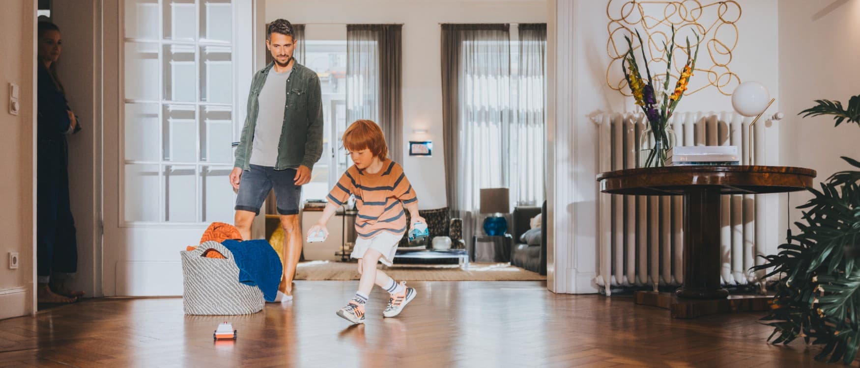 Otac gleda sina kako se igra u dnevnoj sobi